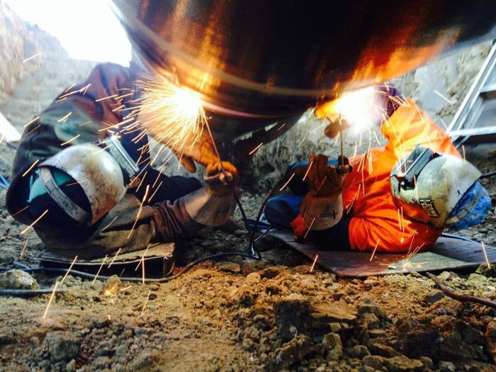 A Midwest welder at work on a pipeline
