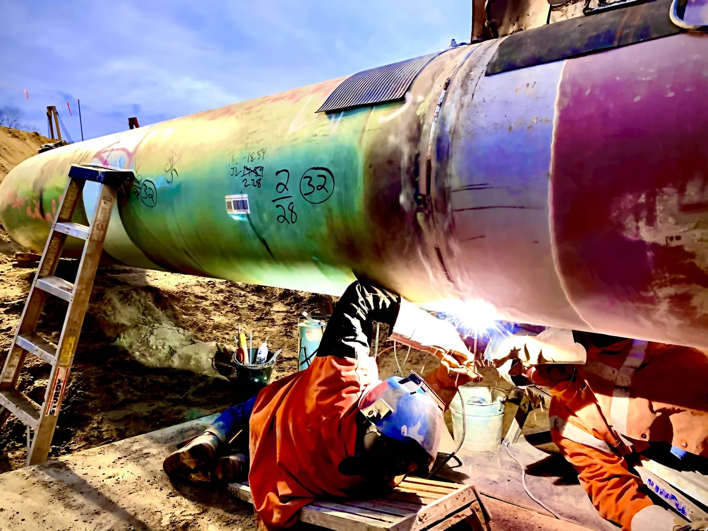 Midwest welders working on a large-diameter pipe joint in the field