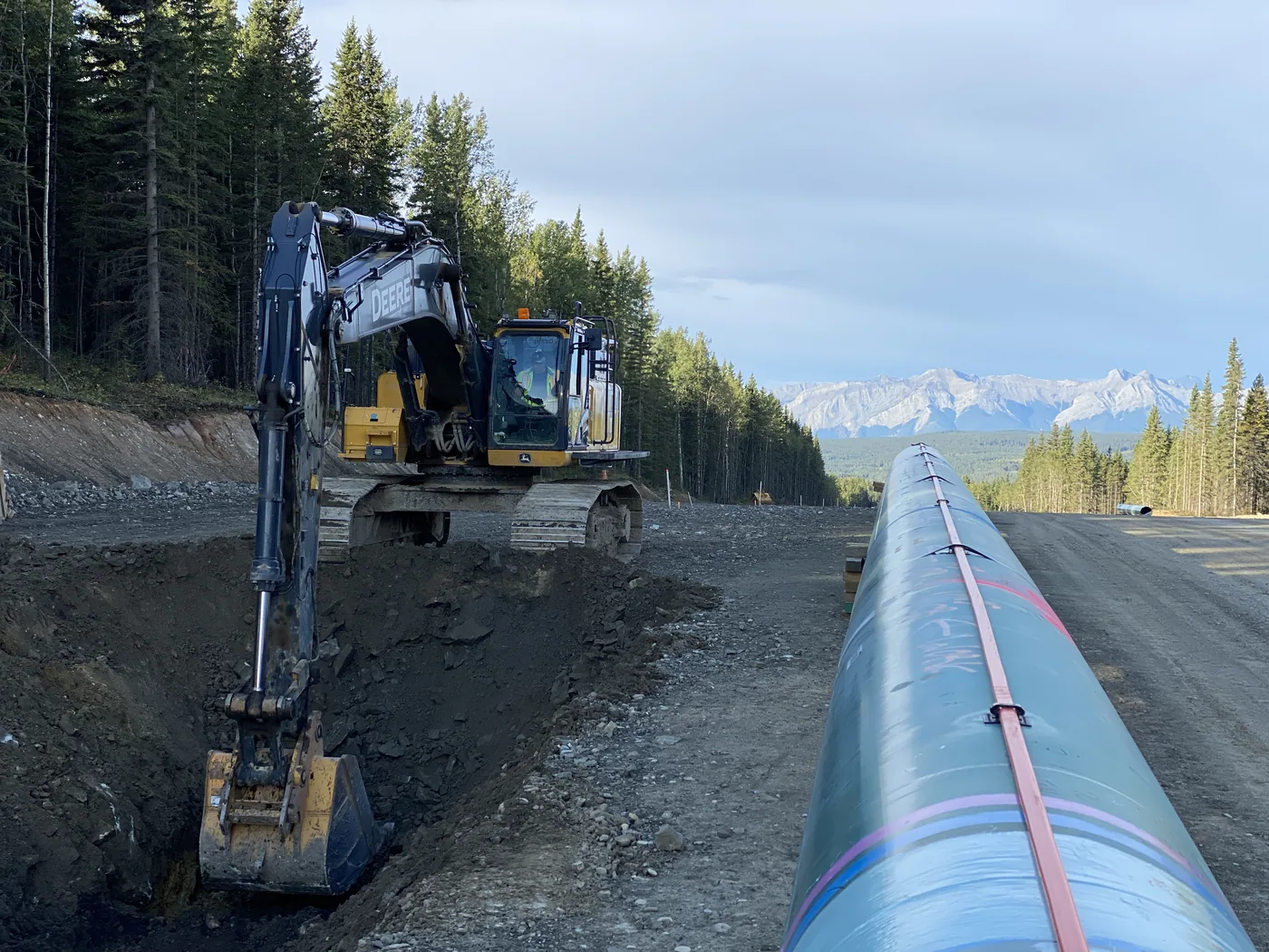 Pipe and an excavator along a mountain construction corridor