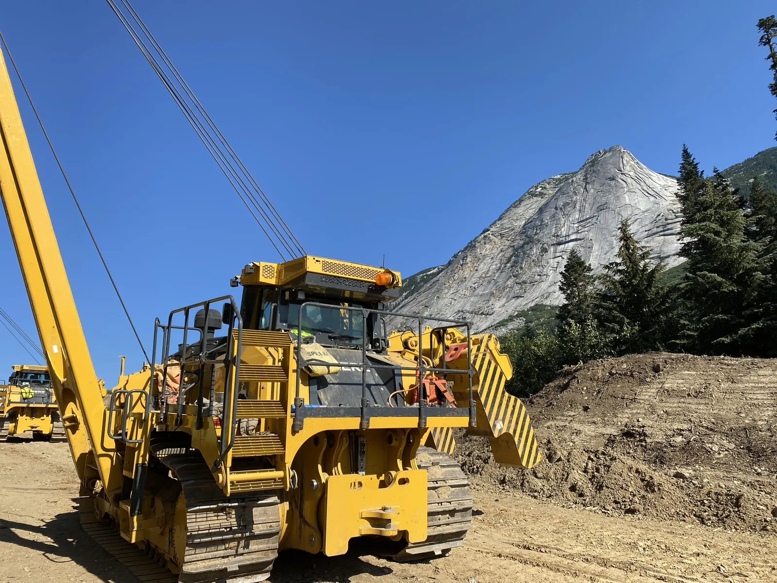 A yellow PL220 pipelayer at a mountain construction site